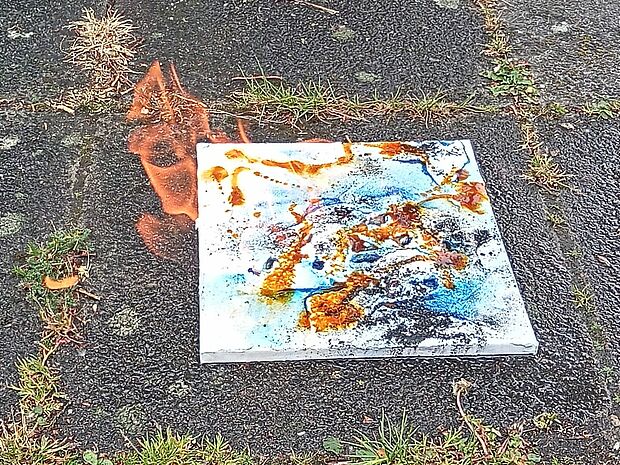 Eine Malerei liegt auf dem farbigen Boden.