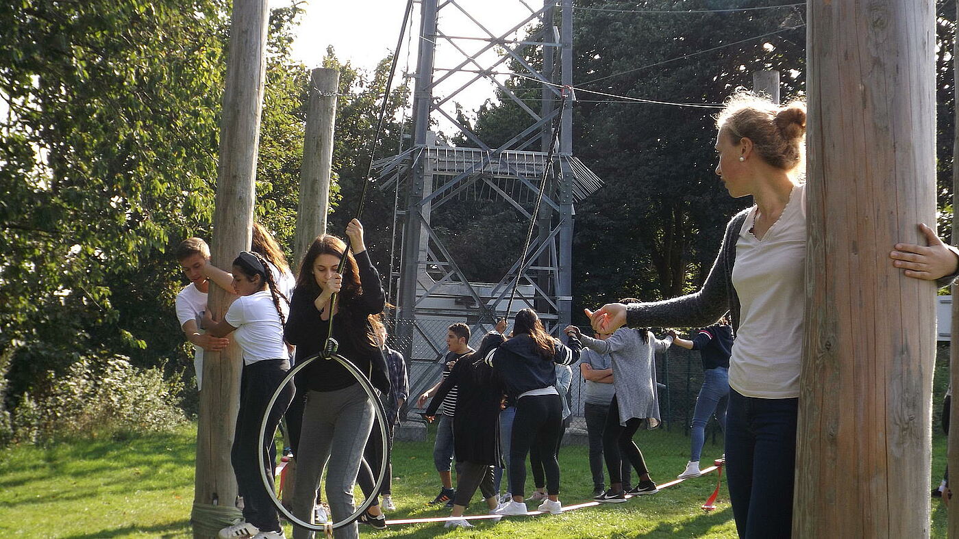 Ältere Schülerinnen und Schüler auf einem Hindernis-Parcours.