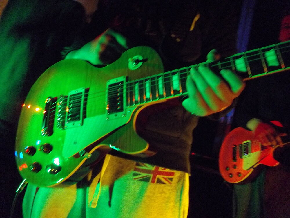 Eine elektrische Gitarre im Bühnenlicht.